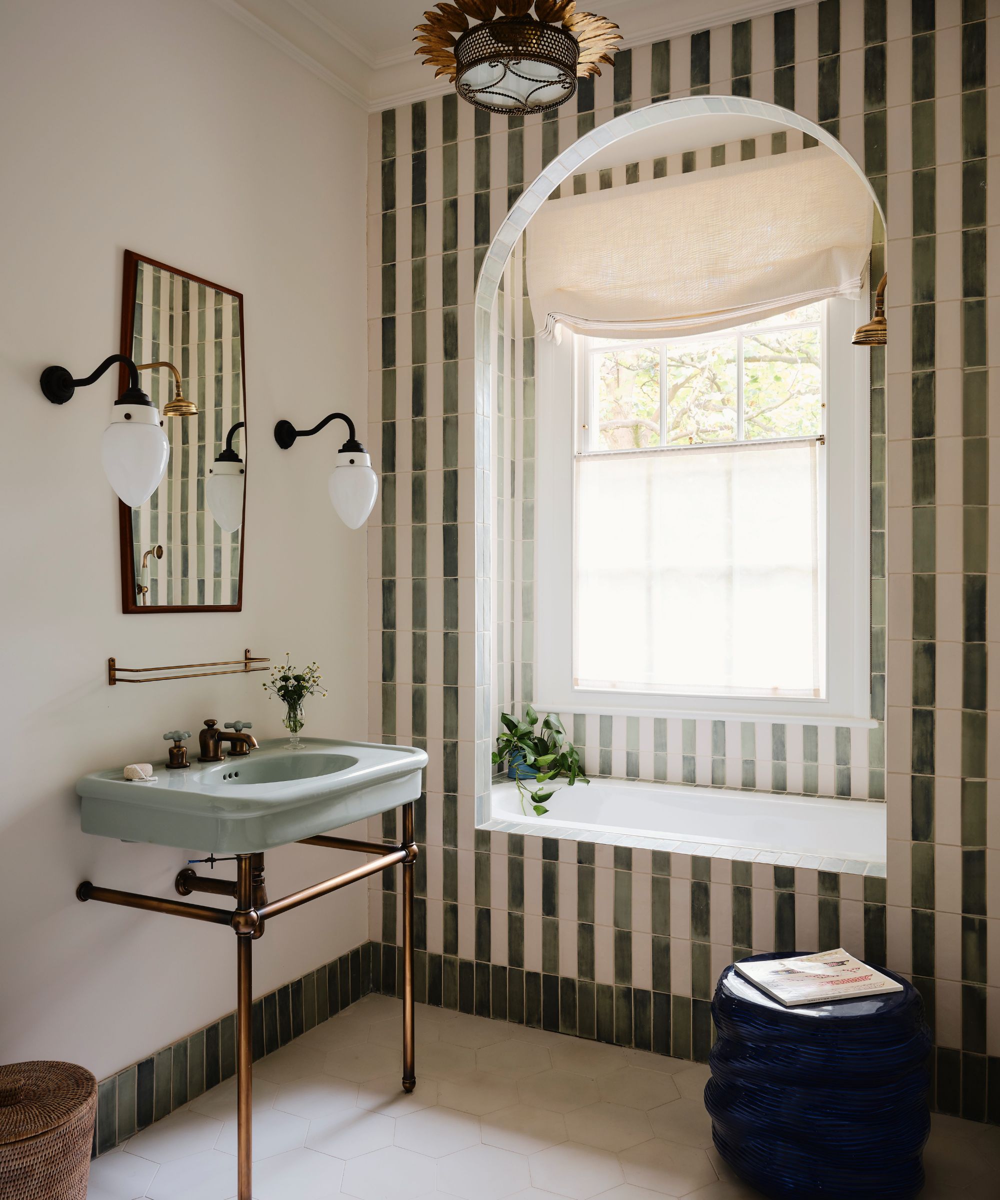A small bathroom with striped tiles creating a bath nook