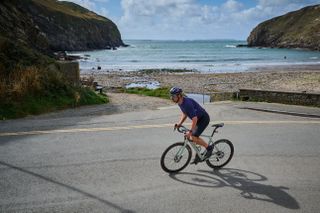 A cyclist riding next to the Welsh coast