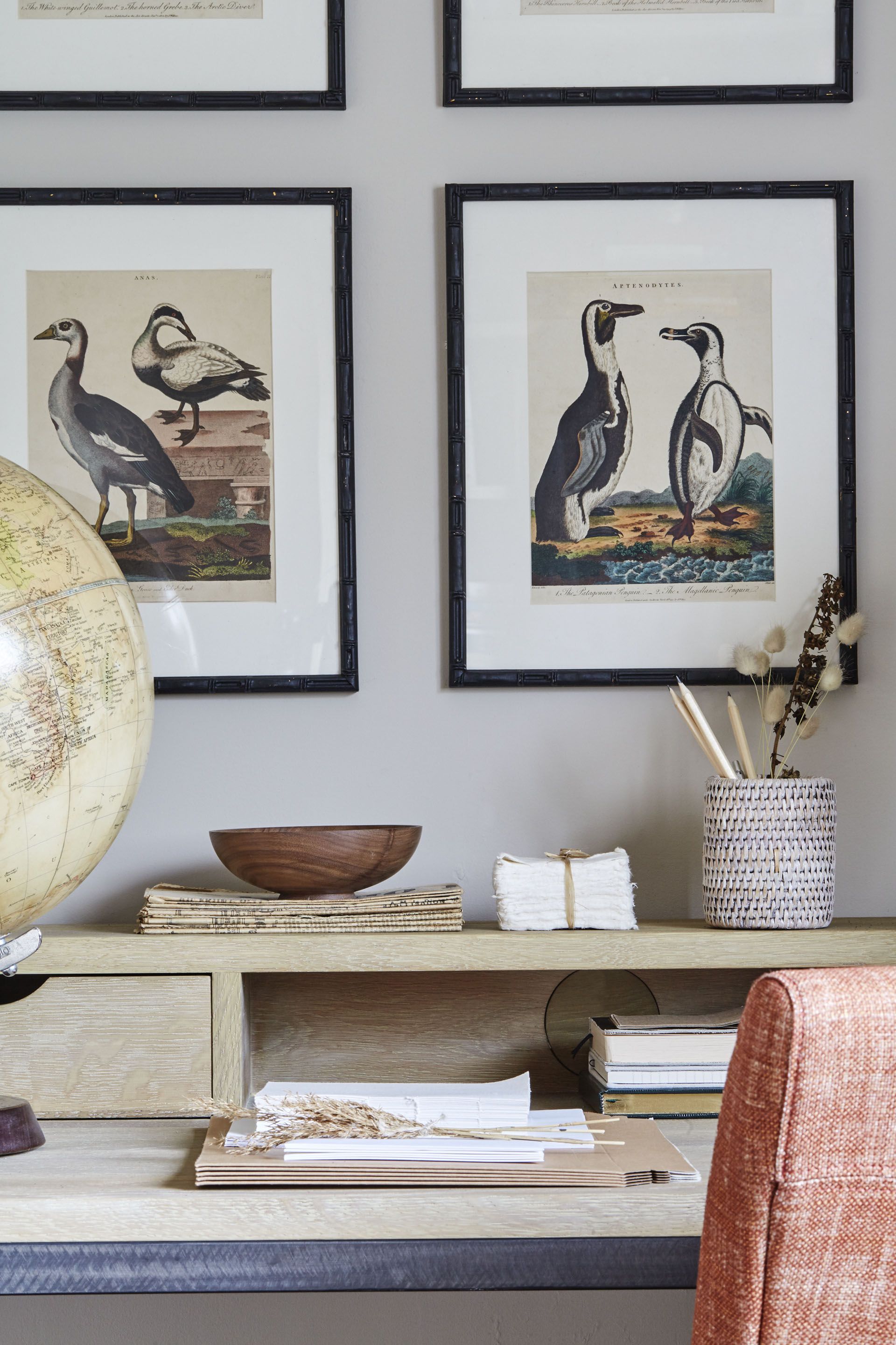 Framed bird pictures, wooden desk, orange chair