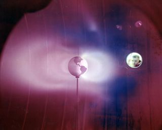 In this 1966 photo, a plasma thruster at NASA's Lewis Research Center simulates Van Allen Belts, rings of radiation around the Earth. The Cleveland, Ohio, center is now John H. Glenn Research Center.