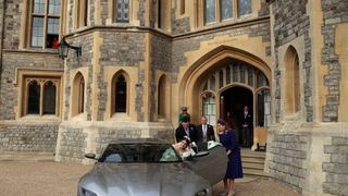 Princess Eugenie and Jack Brooksbank helped by Princess Beatrice and Prince Andrew, Duke of York leave Windsor Castle in an Aston Martin DB10 after their wedding for an evening reception at Royal Lodge on October 12, 2018 in Windsor, England.