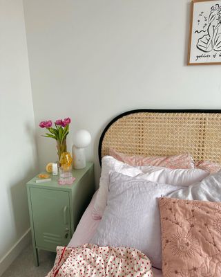 Green nightstand next to neutral bed