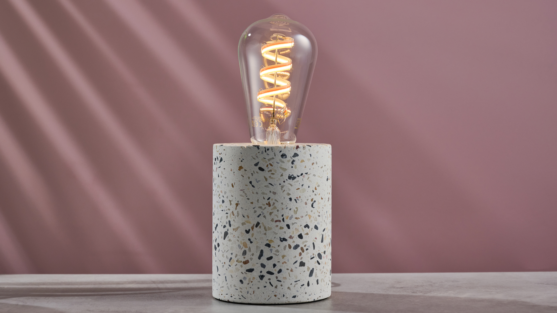The WiZ filament bulb is emitting a warm white.