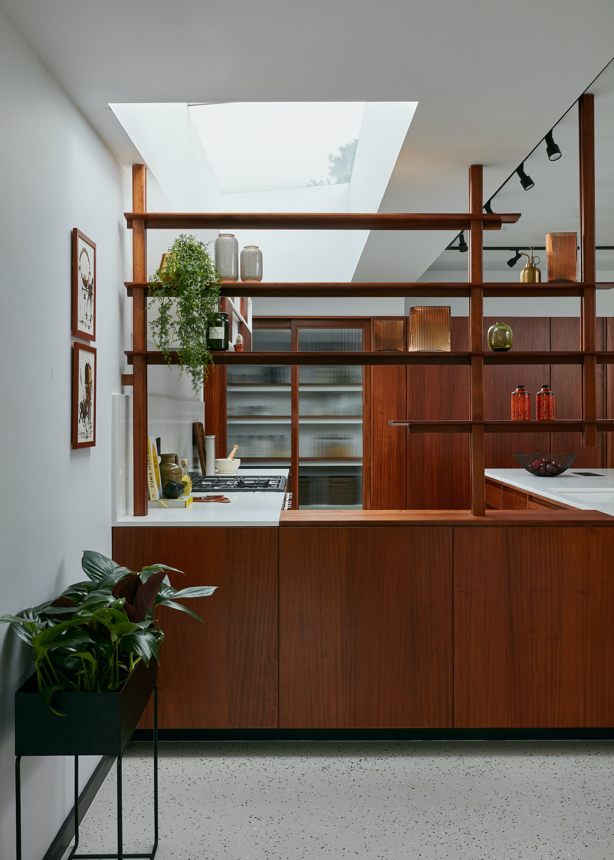 Kitchen with open shelf divider in dark wood