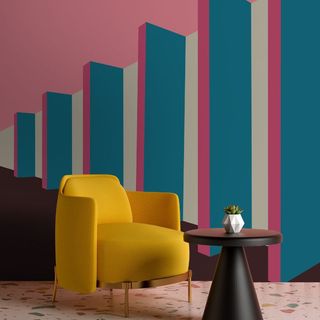 A bright pink, white and blue rectangle mural on a wall behind a yellow chair and black coffee table