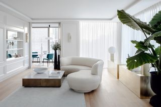 Cozy minimalist living room with sheer linen curtains and a white curved sofa