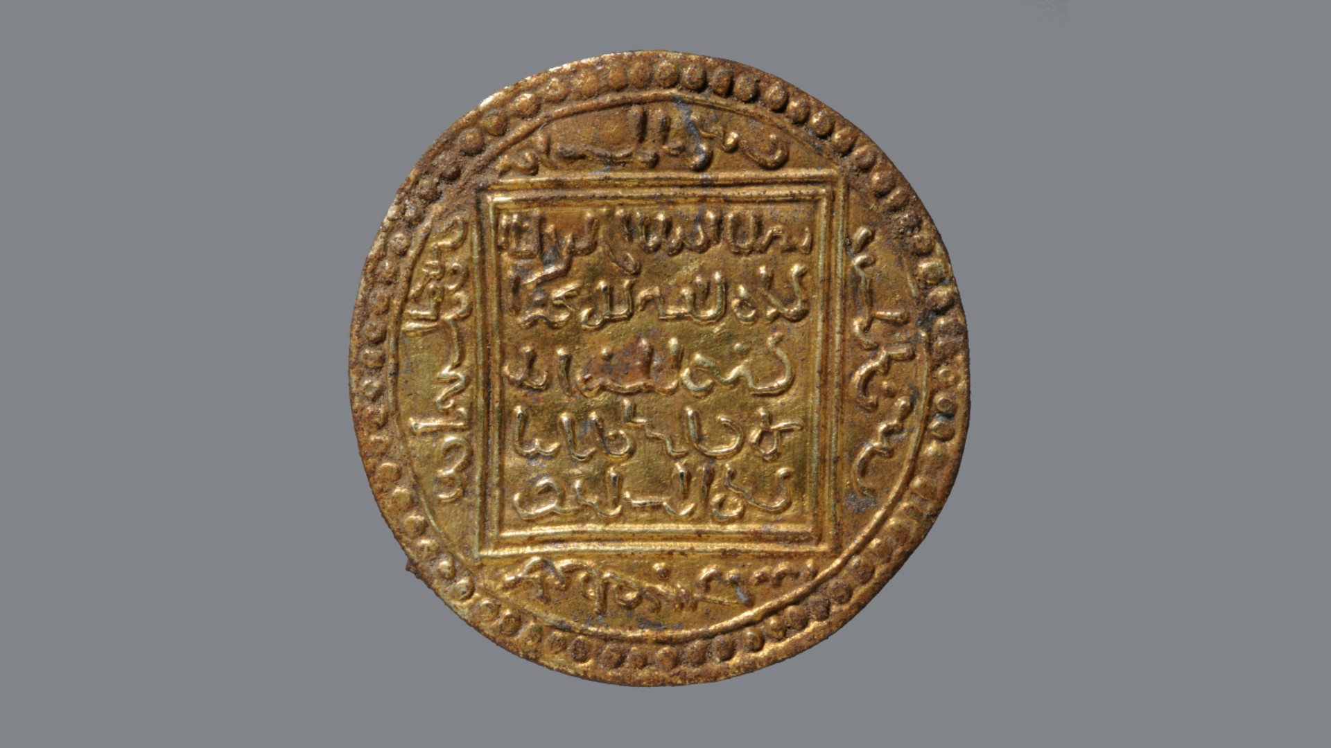 A gilded pseudo-coin fibula. This imitation Islamic coin was fashioned into a brooch.