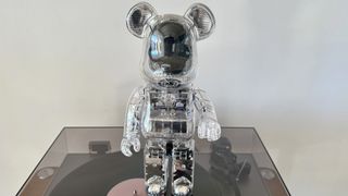 The BE@RBRICK Audio stood on top of a vinyl player 