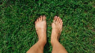 Two bare feet standing on grass