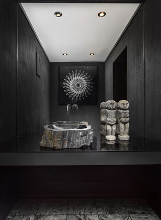 A black bathroom with stone basin