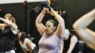 Woman swinging kettlebell in gym