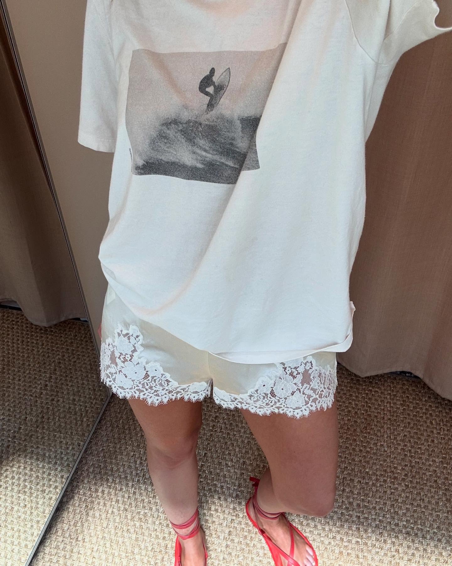 makenna alyse wears a graphic tee, silk shorts and red sandals