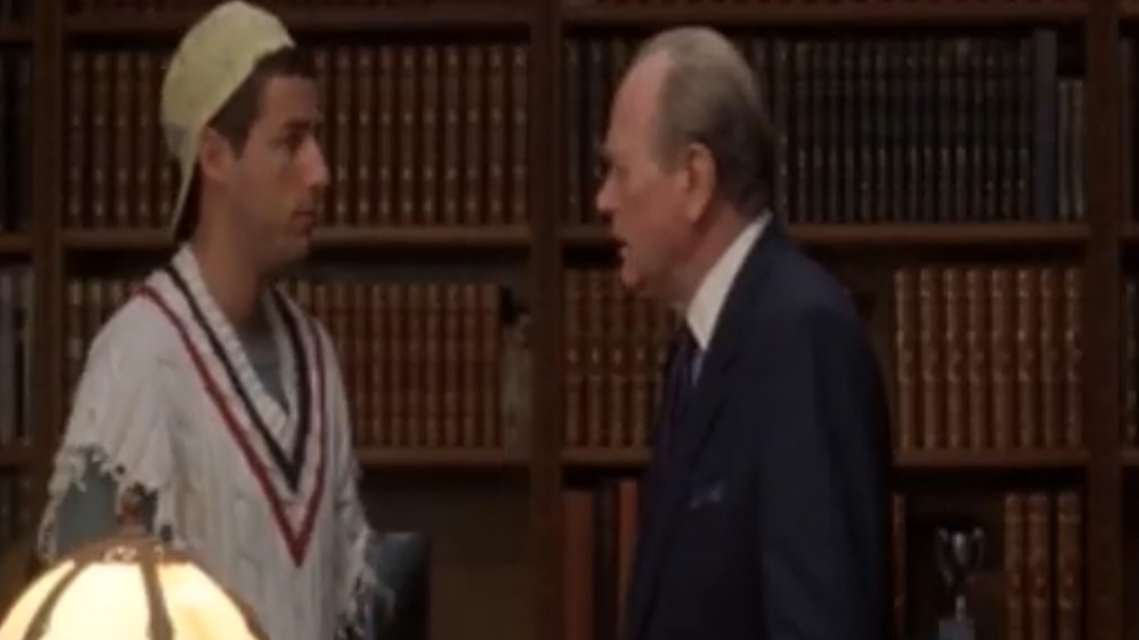 Adam Sandler in a hat and sleeveless sweater talks to Darren McGavin, who is wearing a suit, in Billy Madison.