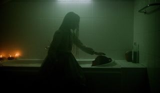 Haunted girl patting head of woman in tub Netflix