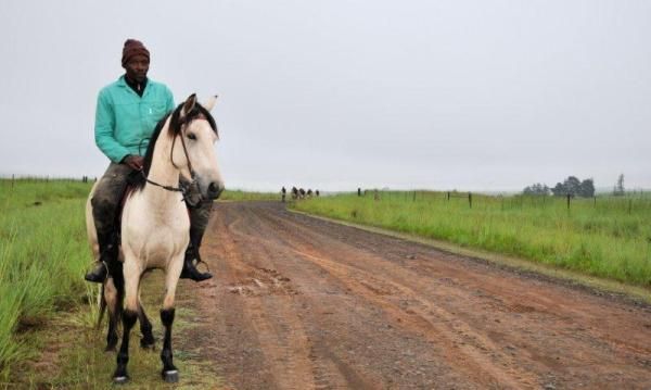 Horsemen look on as the leaders ride past.