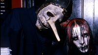Chris Fehn and Joey Jordison sporting their Slipknot masks and posing together backstage in 2000