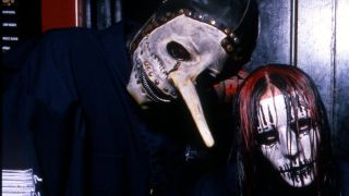 Chris Fehn and Joey Jordison sporting their Slipknot masks and posing together backstage in 2000