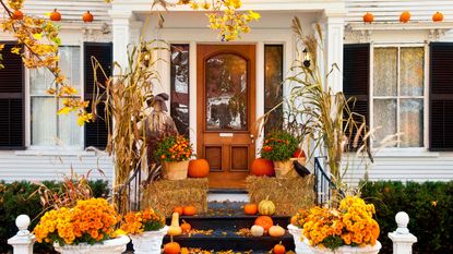 halloween porch decor with pumpkins and corn