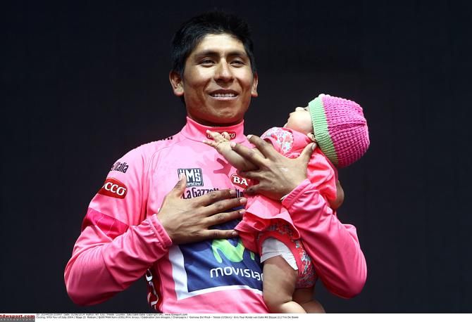 Nairo Quintana enjoys his national anthem with his child on the podium