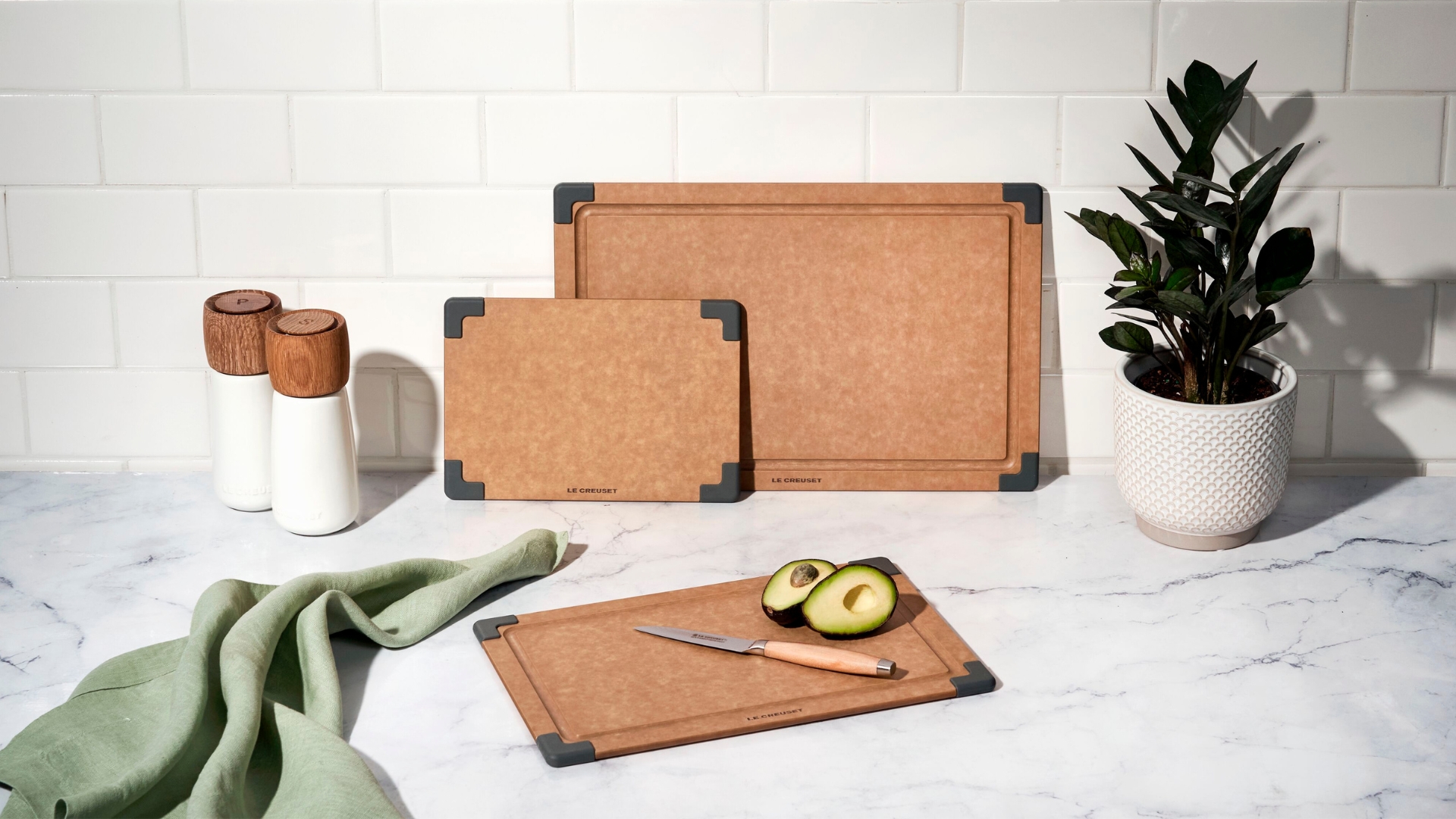 Le Creuset Wood Fibre Chopping Board in a kitchen with an avocado being cut open
