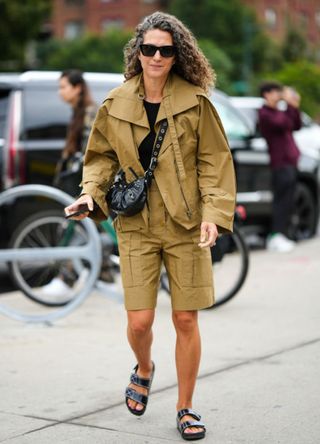 A woman in New York wearing khaki cargo shorts with sandals.