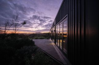 Exterior of New Zealand Coast House by Stacey Farrell, seen at dusk