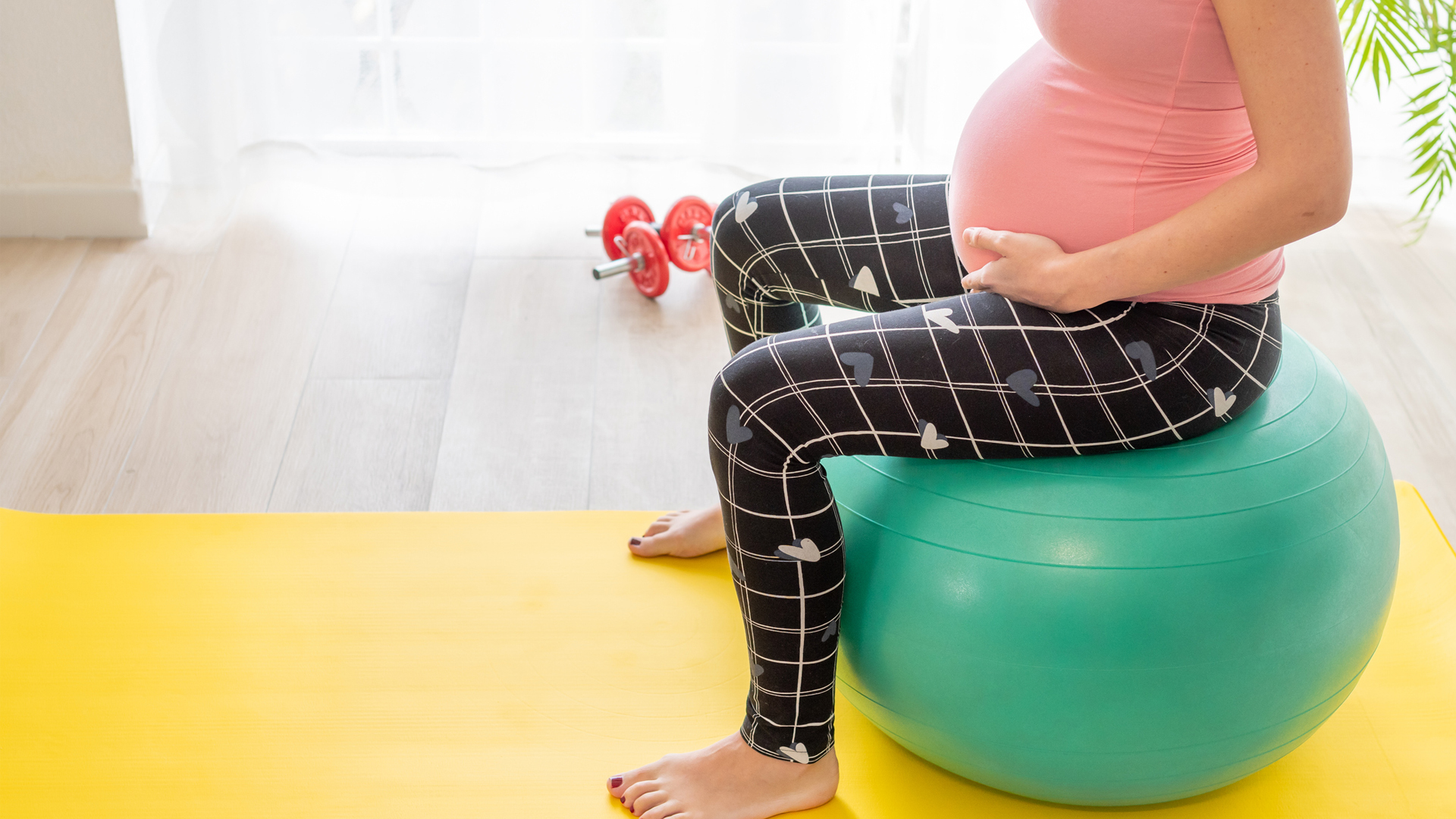 व्यायाम गेंद पर पेल्विक फ्लोर व्यायाम करती हुई गर्भवती महिला