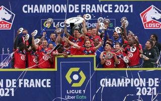 Lille players celebrate with the Ligue 1 trophy after winning the title in 2021.