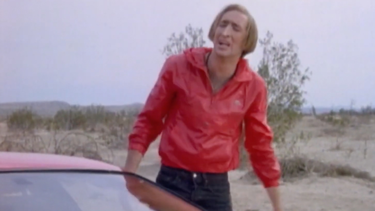 Nicolas Cage in an uncredited cameo as a nerdy guy in a red jacket and red Camero, 1989's Never on Tuesday.