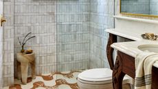 a bathroom with a wavy floor tile and antique vanity