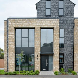 house exterior with brick walls and black door