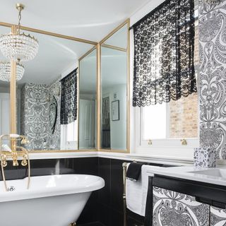 bathroom with mirror chandelier and white bathtub