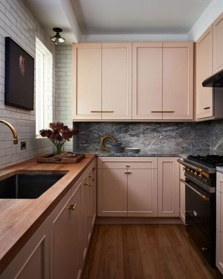 kitchen with pink cabinets and grey marble backsplash