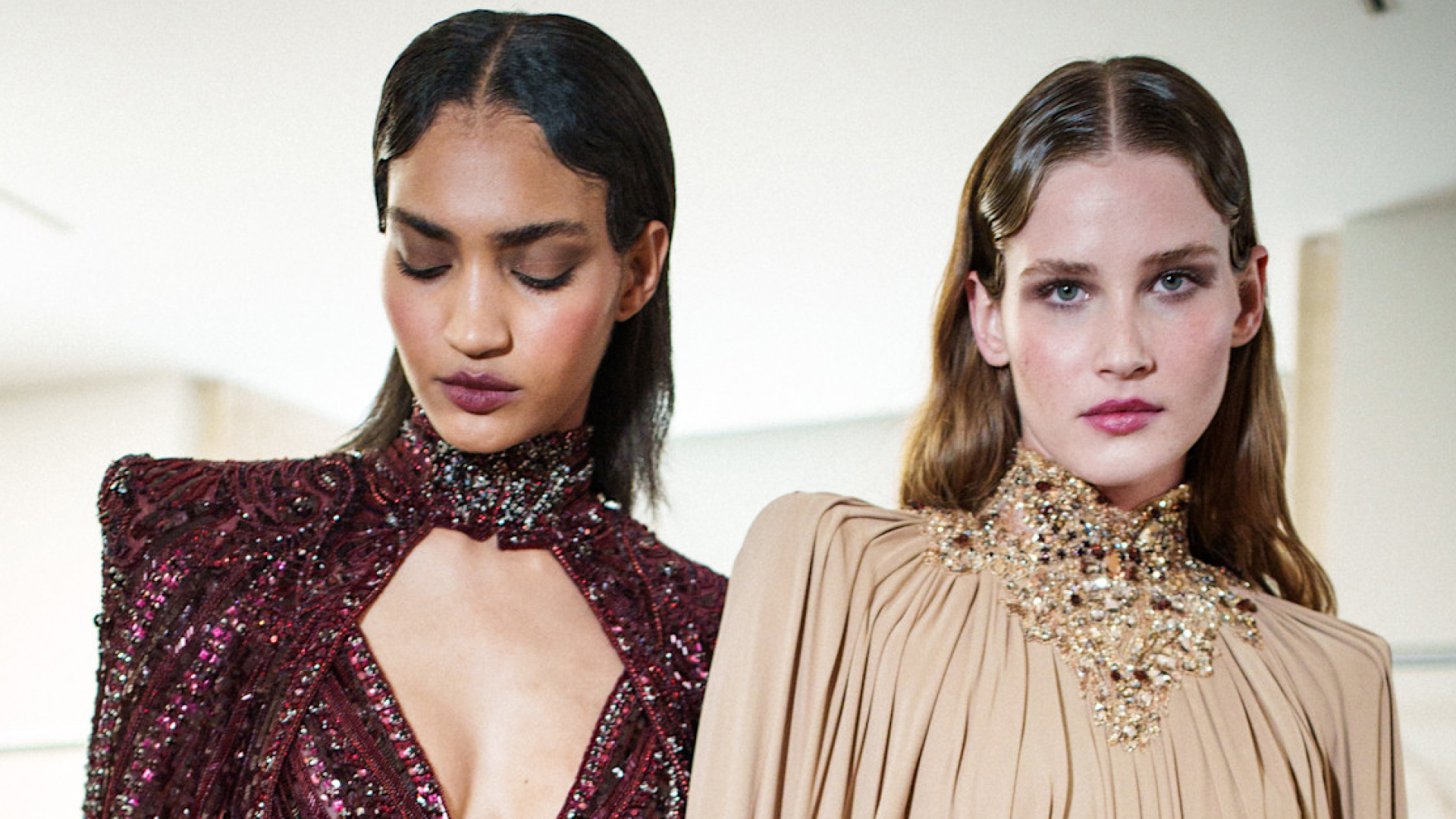 Two models posing for the camera backstage at a show