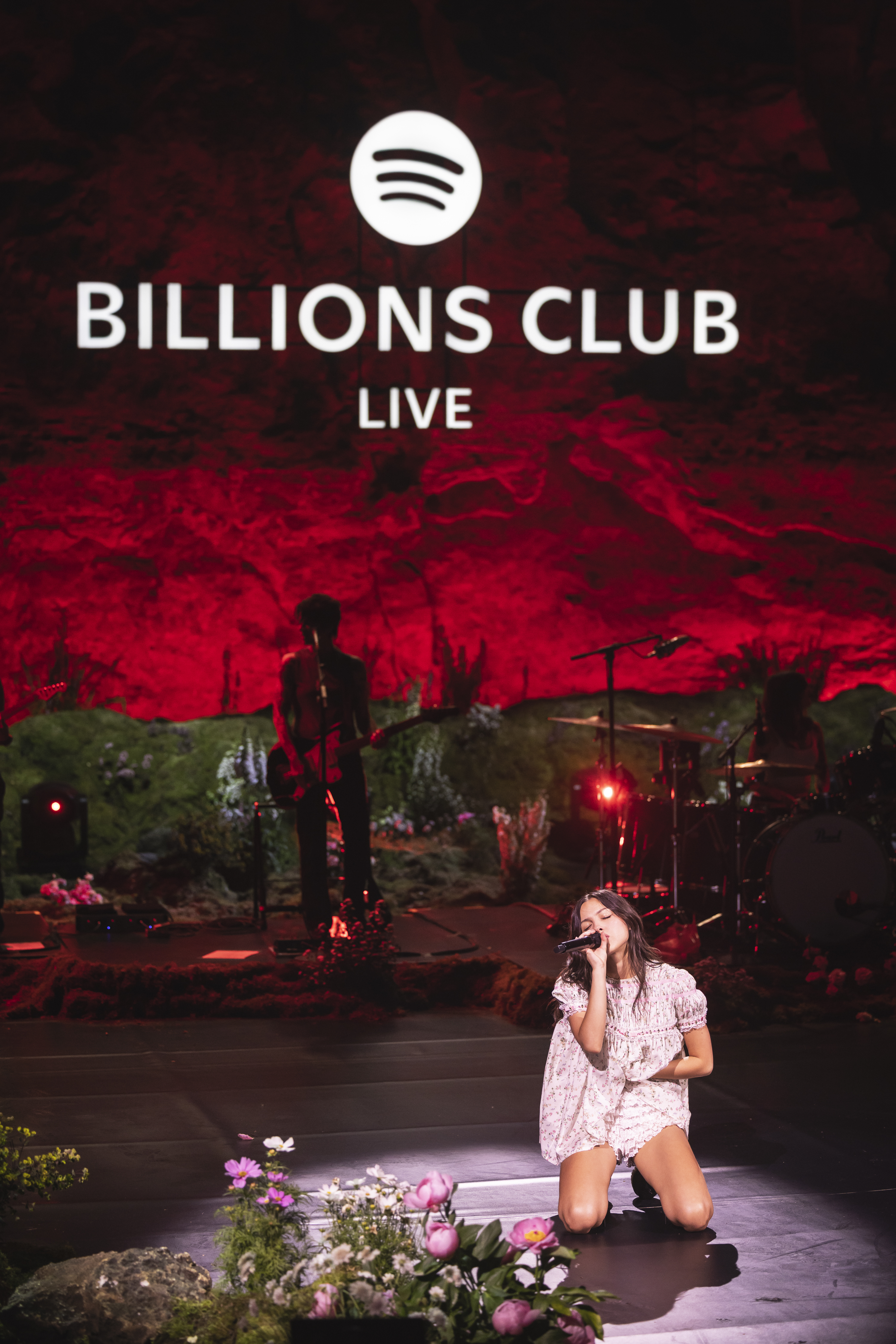 Olivia Rodrigo performs on stage during an exclusive Billions Club Live show to celebrate the partnership between Spotify and FC Barcelona wearing a babydoll floral dress