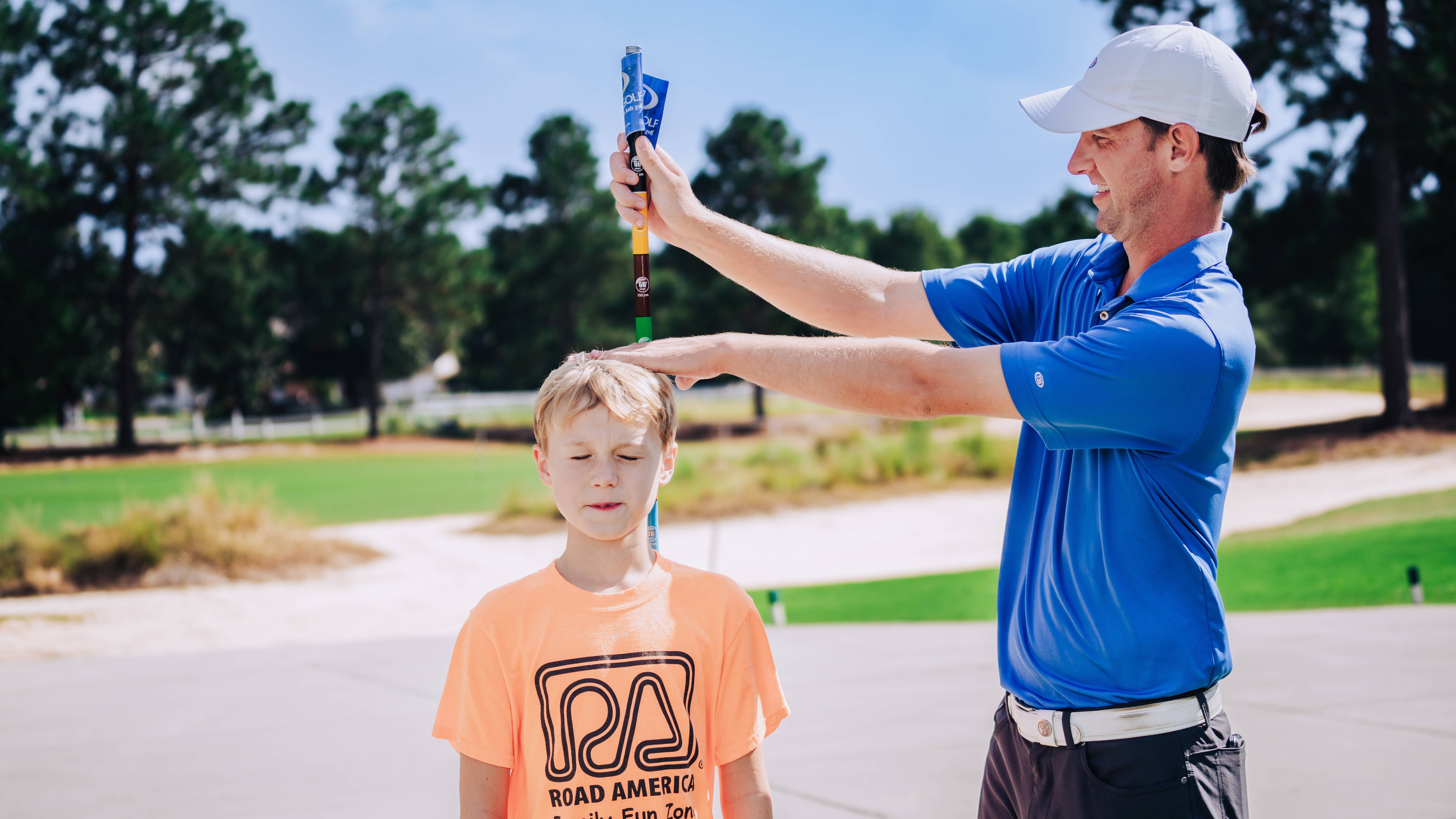 A junior golfer being measured for clubs from USKIDS Golf