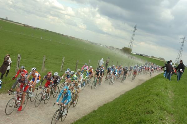The peloton on some dusty cobbles.