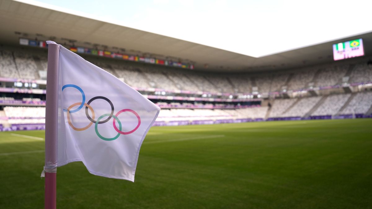 The Olympic flags before a football stadium.