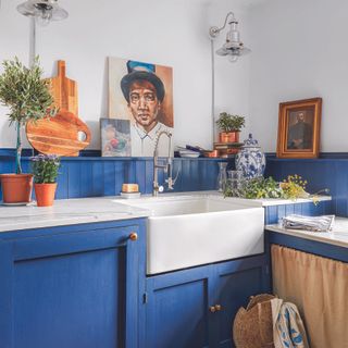 Bright blue shaker kitchen with white belfast sink.
