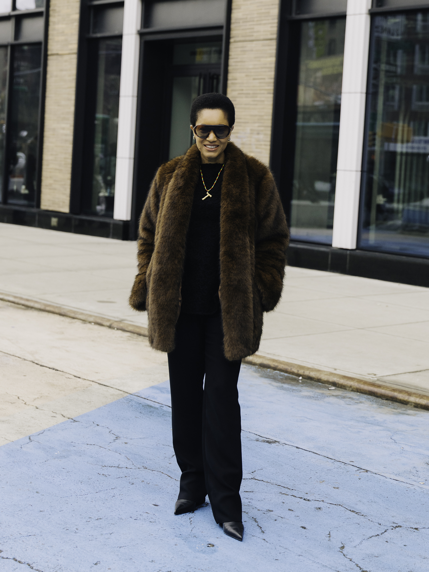 woman wearing fur jacket, black top, black pants, and boots