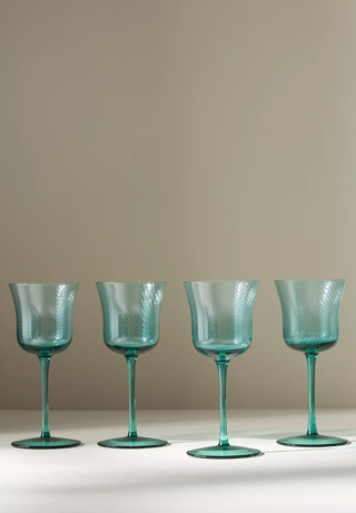 four teal wine glasses in a row