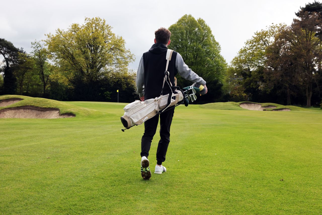 Dan Parker walking with the Sunday Loma XL stand bag over one shoulder