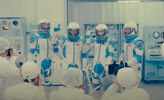 Four astronauts dressed in retro-styled spacesuits