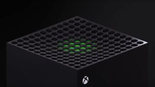 En närbild på ovansidan av en Xbox Series X, med ett grönt svagt ljus som lyser från konsolen och Xbox-logon i ena hörnet.