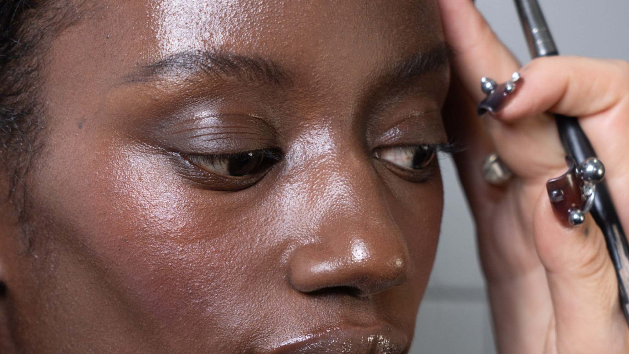 model with glowy skin having skincare applied backstage