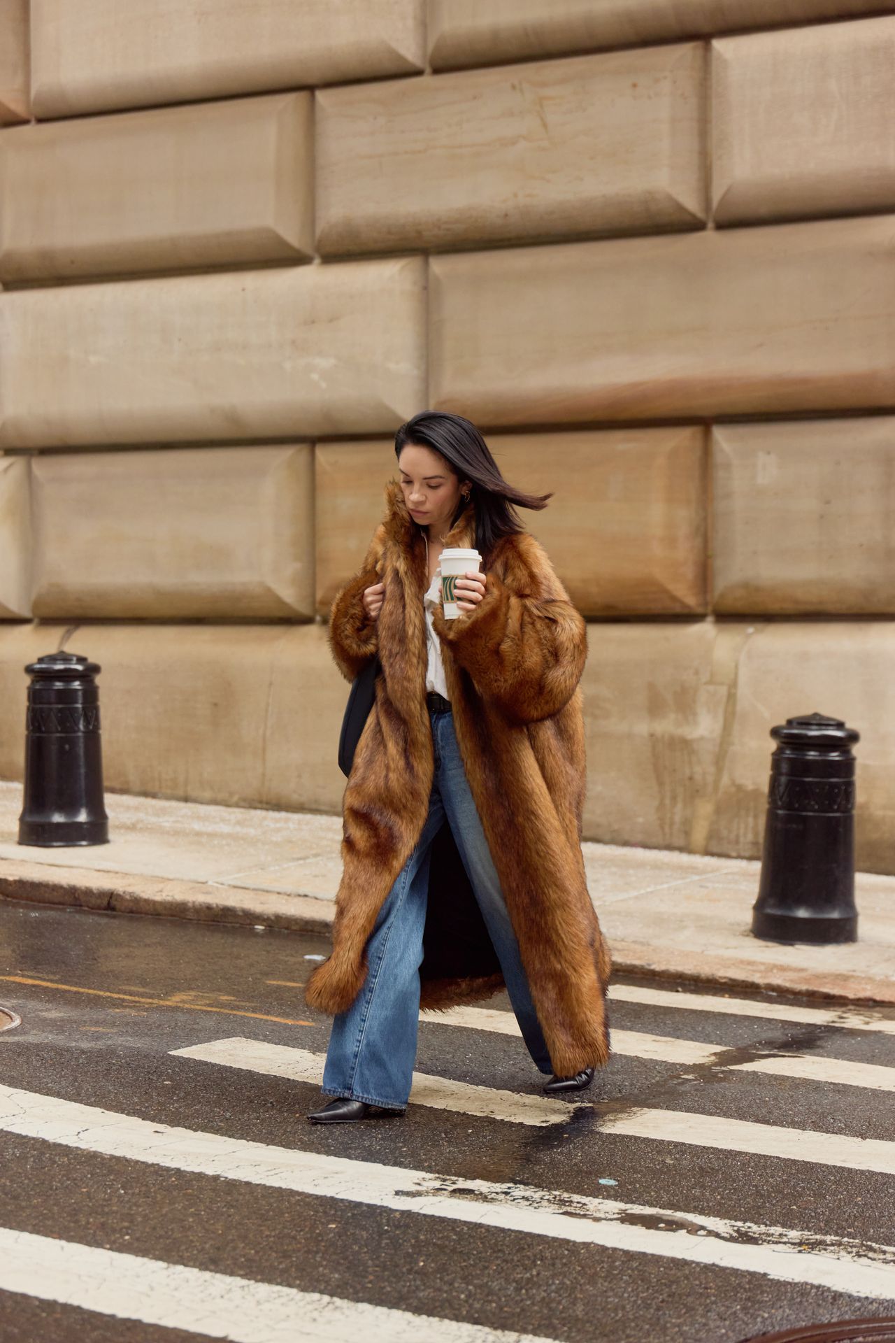 A woman wearing a brown fur coat with jeans during F/W 25 fashion week in New York.
