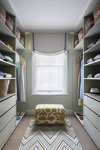 A walk-in closet with a window and open shelves
