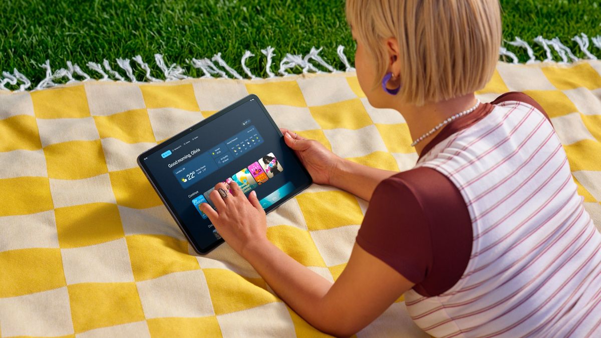 A girl using the Amazon Alexa Tablet 12 Pro on a picnic blanket