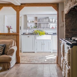 View through to pale blue cottage kitchen with Belfast sink and plate rack