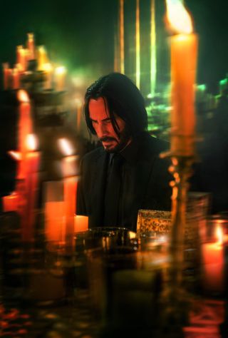 Keanu Reeves' John Wick in Chapter 4 kneeling before numerous candles